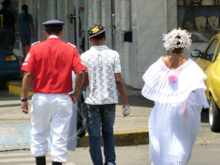 3 people with diverse attire leaving Fair in David, Panama