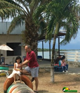 beachfront park, palm trees, cafe, young girl & man on tire structure