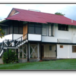 White wooden house with red roof