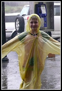 Little girl wearing yellow rain poncho in rain