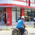 man on motor cycle looking back over shoulder on an urban street