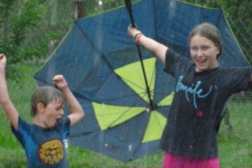 Two children celebrating in the rain