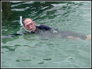 Man in water with snorkeling gear on.