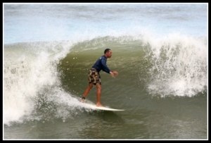 Man surfing an Ocean Wave as it it tubing