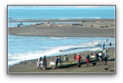 Photo of 10 men bringing fishing boat onto beach