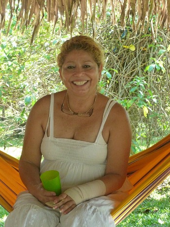 Smiling woman sitting in an orange hammock