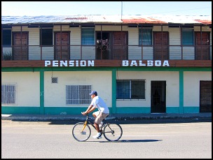 Bicyclist riding down street in front of Pension Balboa