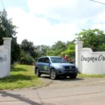 Photo of man waving from car at entrance to Corazon de Oro beach development