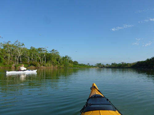 River, bow of kayak, a white kayak, blue sky