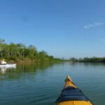 River, bow of kayak, a white kayak, blue sky