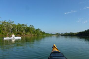 River, bow of kayak, a white kayak, blue sky