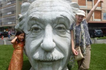 Big Statue of Albert Einstein's head with two young girls posing - in Panama City