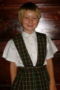 Smiling young girl in plaid 7th Day Adventist school uniform