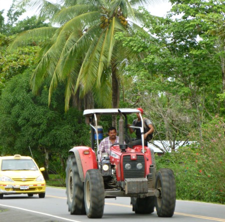 Red tractor & Yellow Taxi On A 2 Lane Road