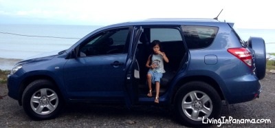 young girl looking out of and eating in our new used car