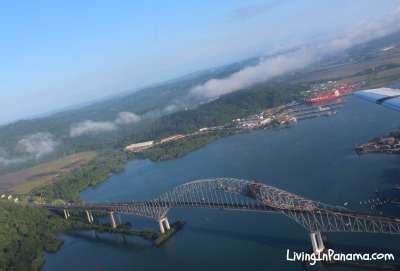 Aerial view of bridge, water, and land from airplane leaving Albrook airport in Panama city