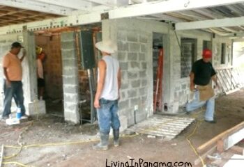 3 workers at a cement block house construction site