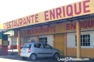 Yellow building with parking lot in front. In red letters, Restaurante Enrique