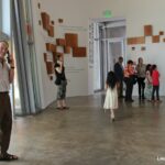 People in big hall in museum with handsets to their ears