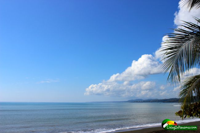 peaceful flat ocean, blue sky, puffy white clouds