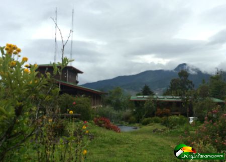 mountain in background, cloudy sky, garden and 2 buildings