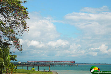 blue sky and ocean with pier in distance