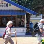 two elderly white people striding through festival