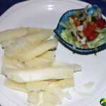 steamed yucca and small salad on white plate