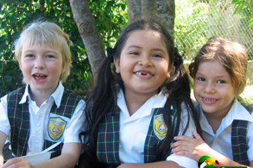 3 girls in school uniforms smiling together