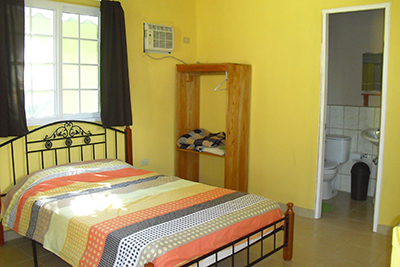 Room with bed and bathroom beyond