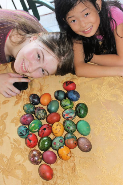 2 girls, white & chinese, with dyed easter eggs