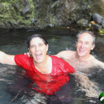 couple submerged, except heads, in a pool of water -