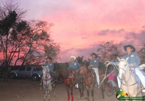group of men on horseback at sunset