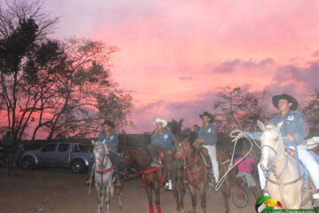 group of men on horseback at sunset