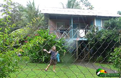 young girl carrying bag of fish in front of a house