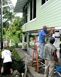 3 men remodeling a wooden house in Panama