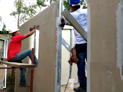 2 men constructing house with steel studs and plycem
