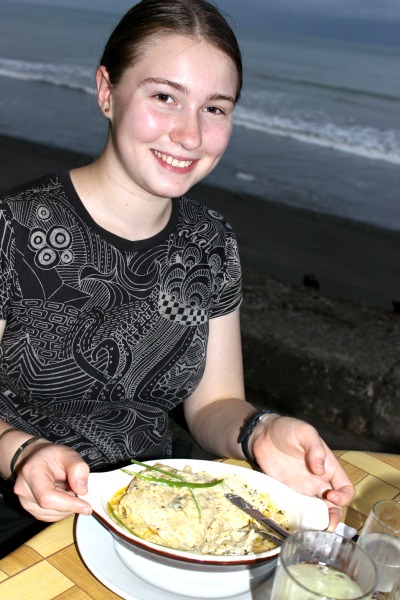 girl at waterfront table with white lasagne