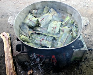 Tamales cooking on an outdoor fire