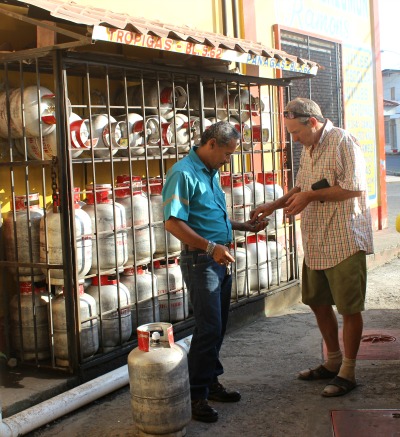 2 men, one paying for a gas bottle from the other