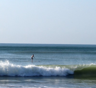 man on stand up paddle board in ocean