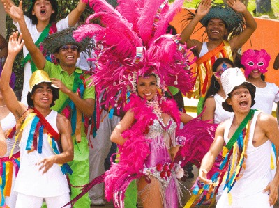carnival queen in pink headdress surrounded by her court