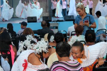 2 girls in traditional Panama dress in audience while others dance