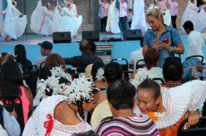 2 girls in traditional Panama dress in audience while others dance