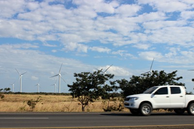 photo of highway with white truck and windmills 