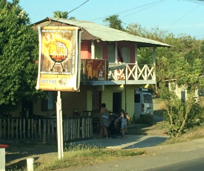 photo of 2 story wooden house with sign for a restaurant