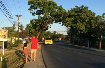 girl and man walking down newly paved road