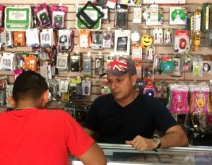 Man behind cell phone counter helping a customer