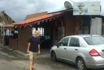 exterior of a Puerto Armuelles restaurant Tisamar with man and car parked in front