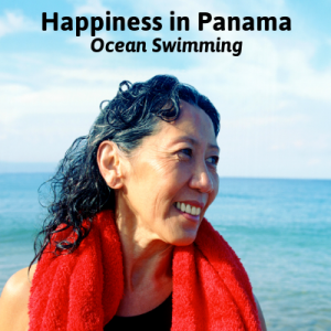 Smiling Asian woman with red towel around neck by the ocean